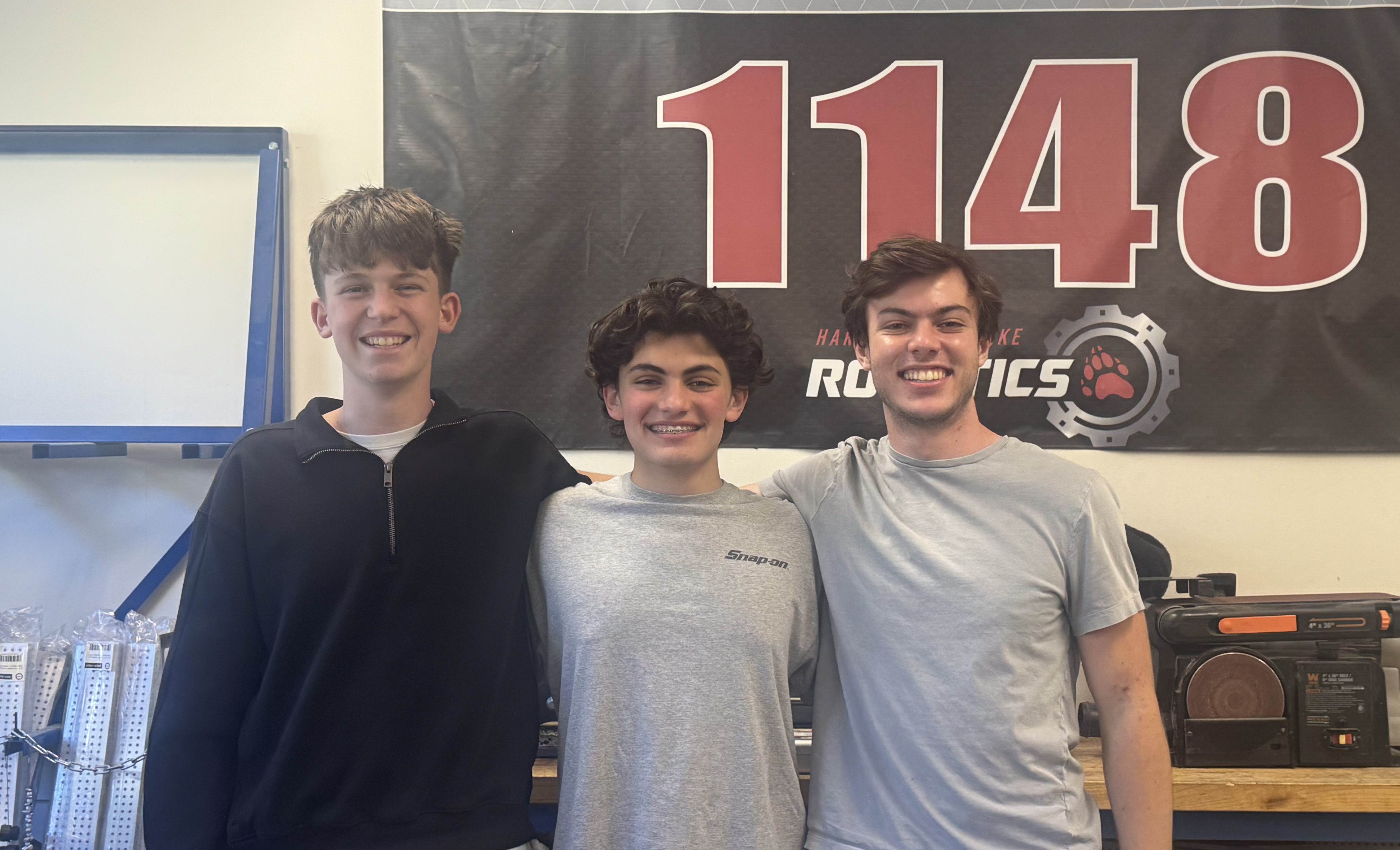 Morgan, Jake, and Matteo in the Harvard-Westlake Robotics room in front of the team 1148 banner